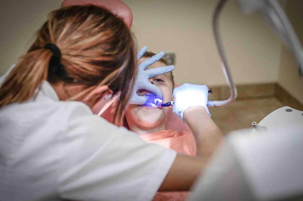 Child getting teeth cleaned by a dental hygienist