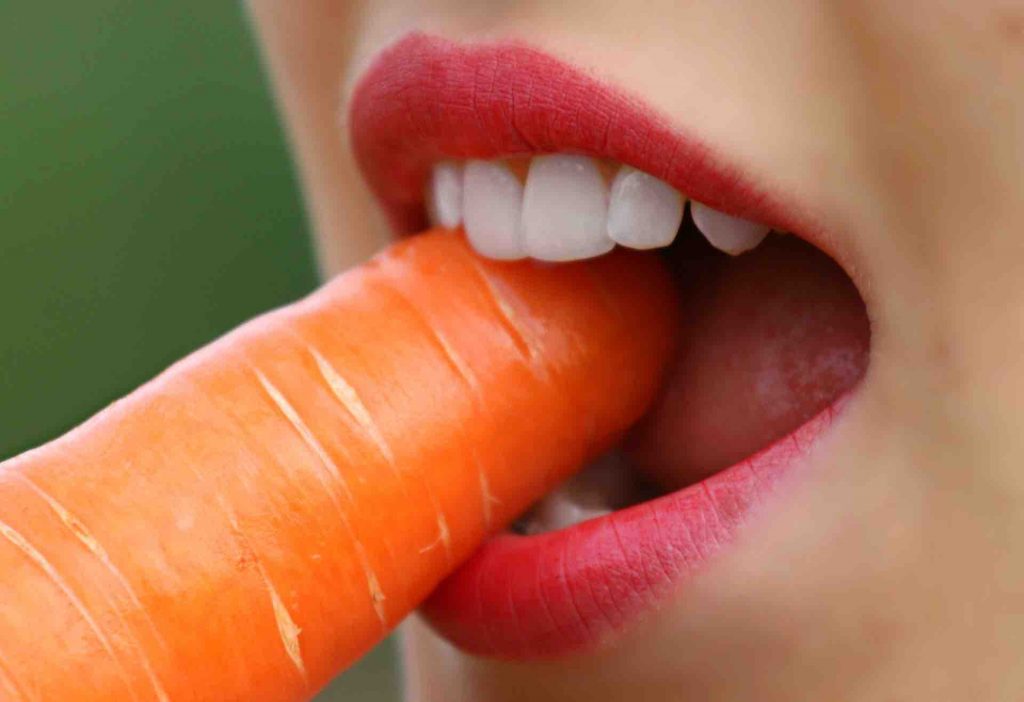 Woman biting a carrot